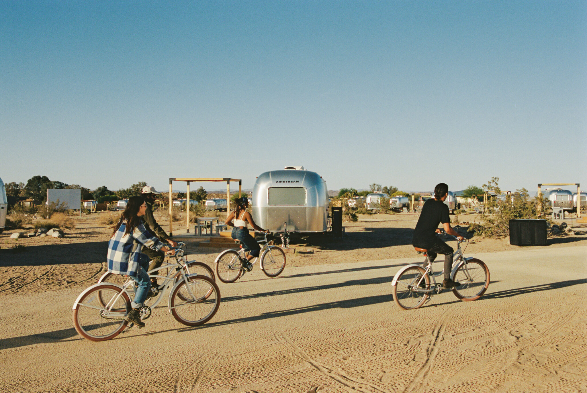 Friends riding bikes around AutoCamp Joshua Tree