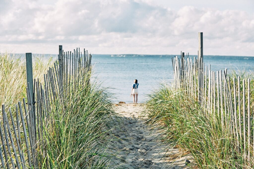 Woman walking on the beach looking at the ocean