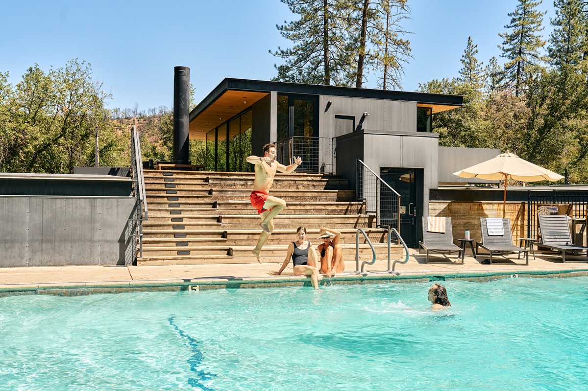 Man jumping into pool with friends