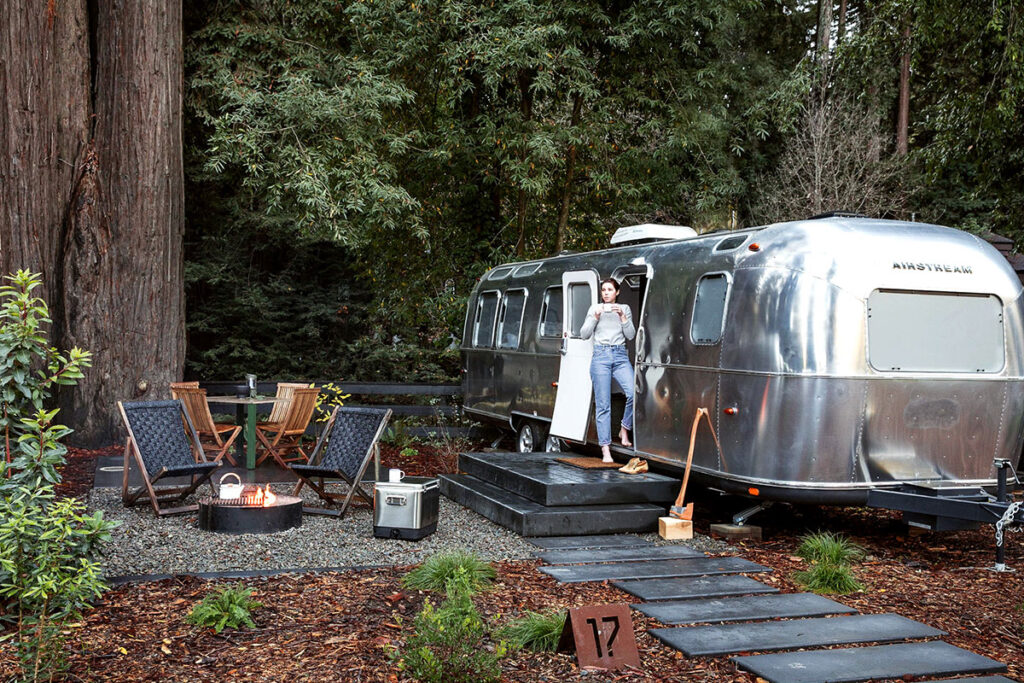 Woman having coffee next to Airstream at AutoCamp Sonoma