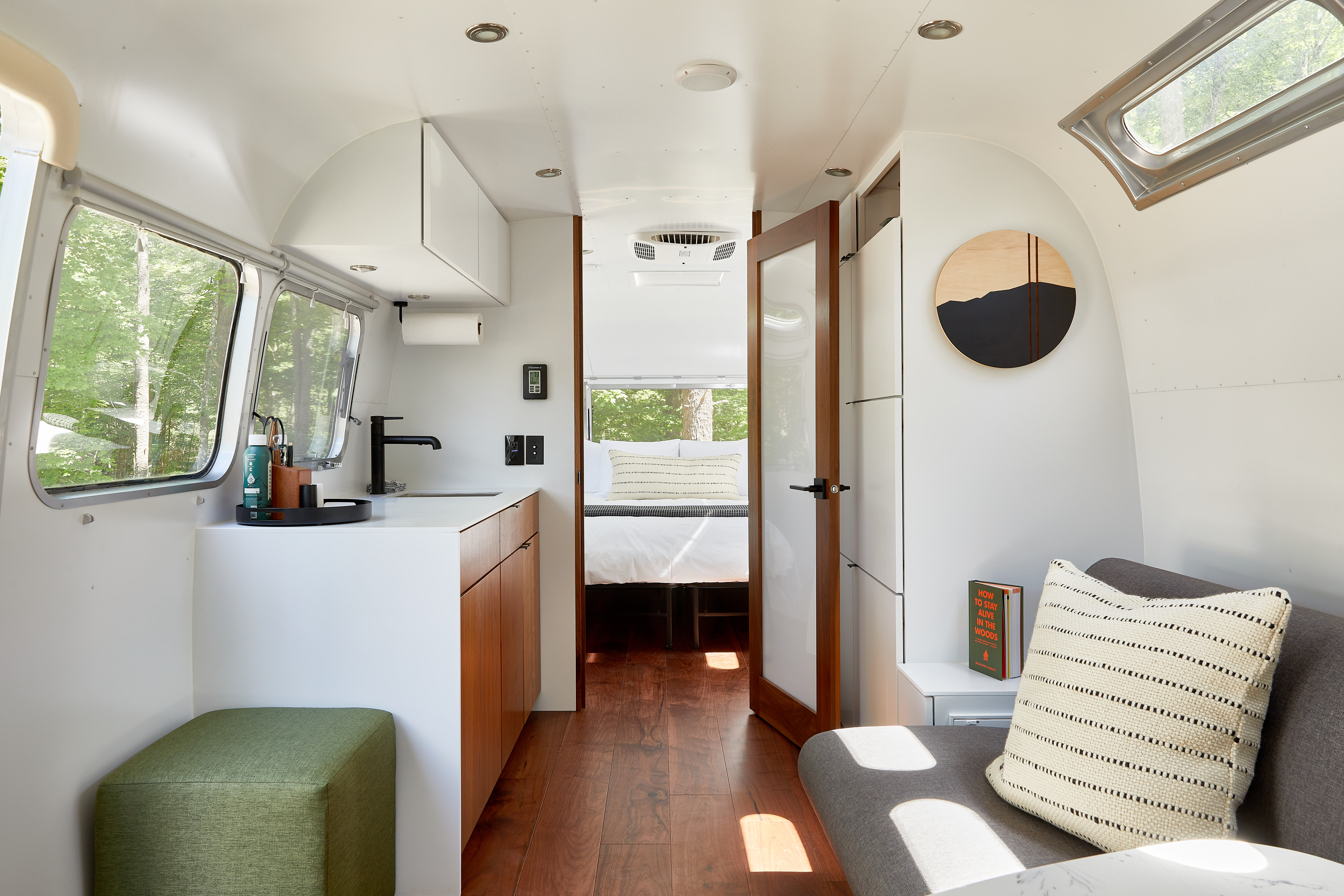 Inside an AutoCamp Airstream: living area and kitchenette looking back to the bedroom