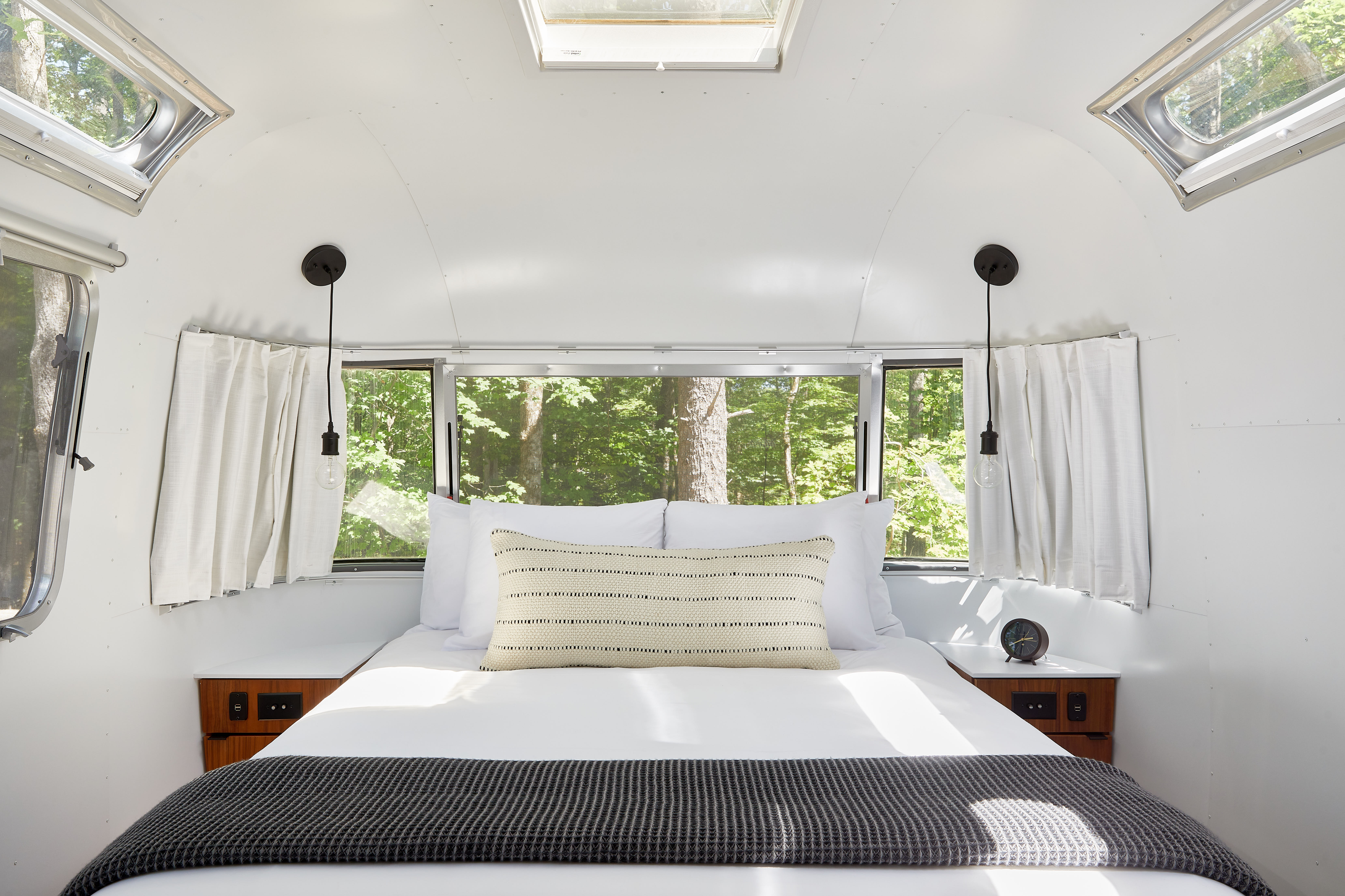 The queen bed at the back of an AutoCamp Airstream