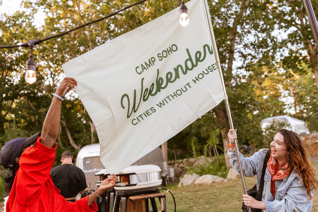 Two women colleagues hoisting a flag for their camp event