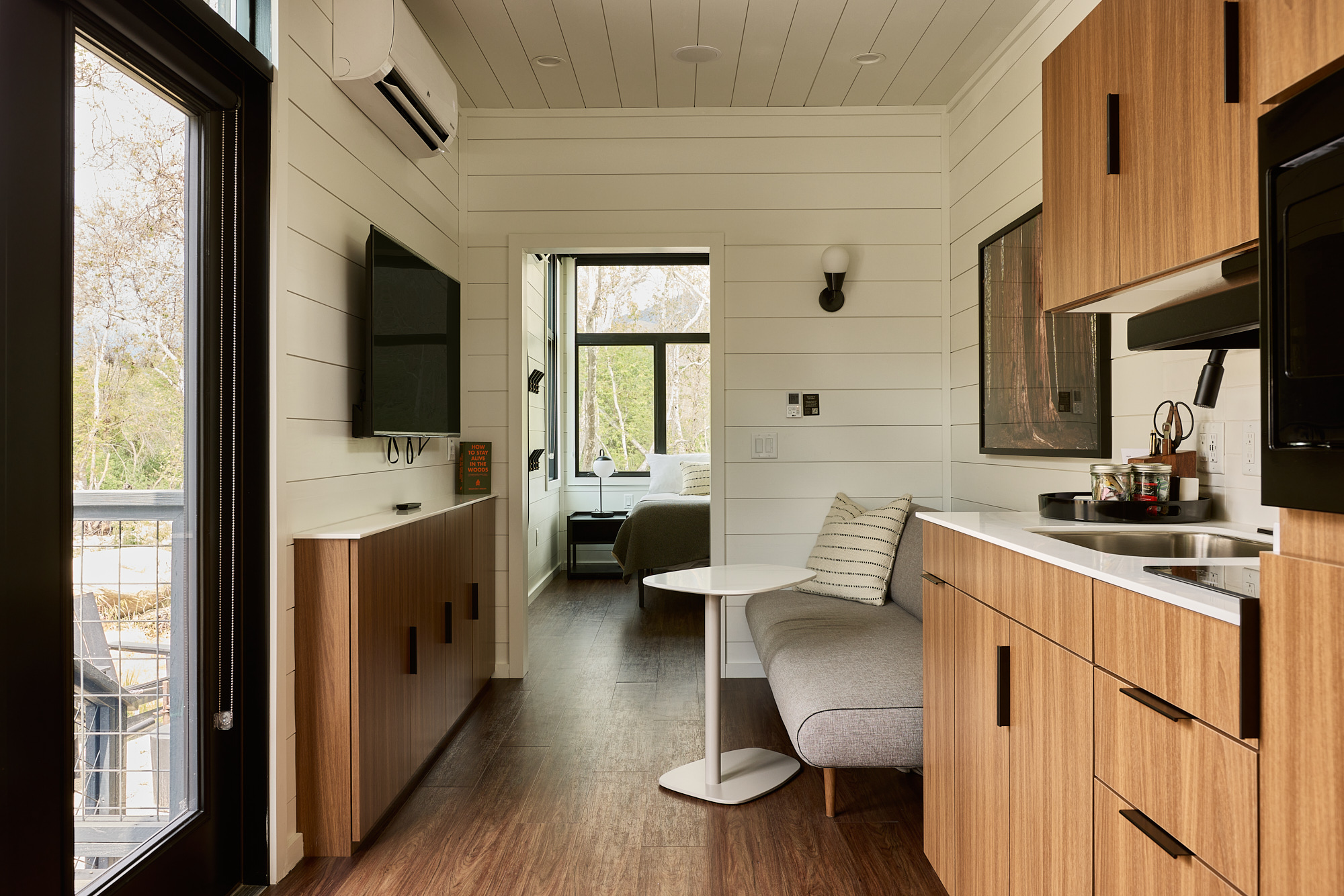 AutoCamp Sequoia cabin suite interior view of kitchenette, living room area and bedroom