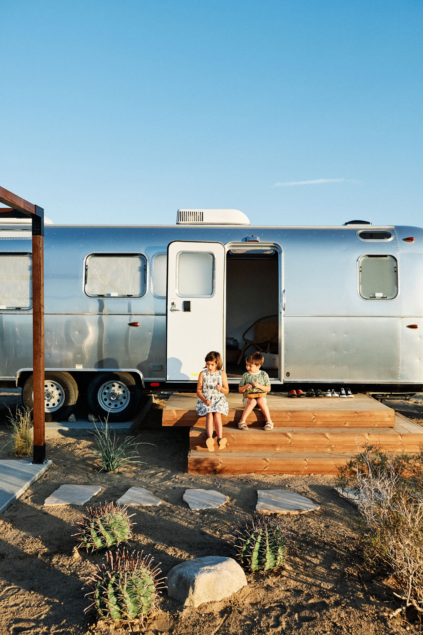 Kids sitting on an Airstream landing in Joshua Tree