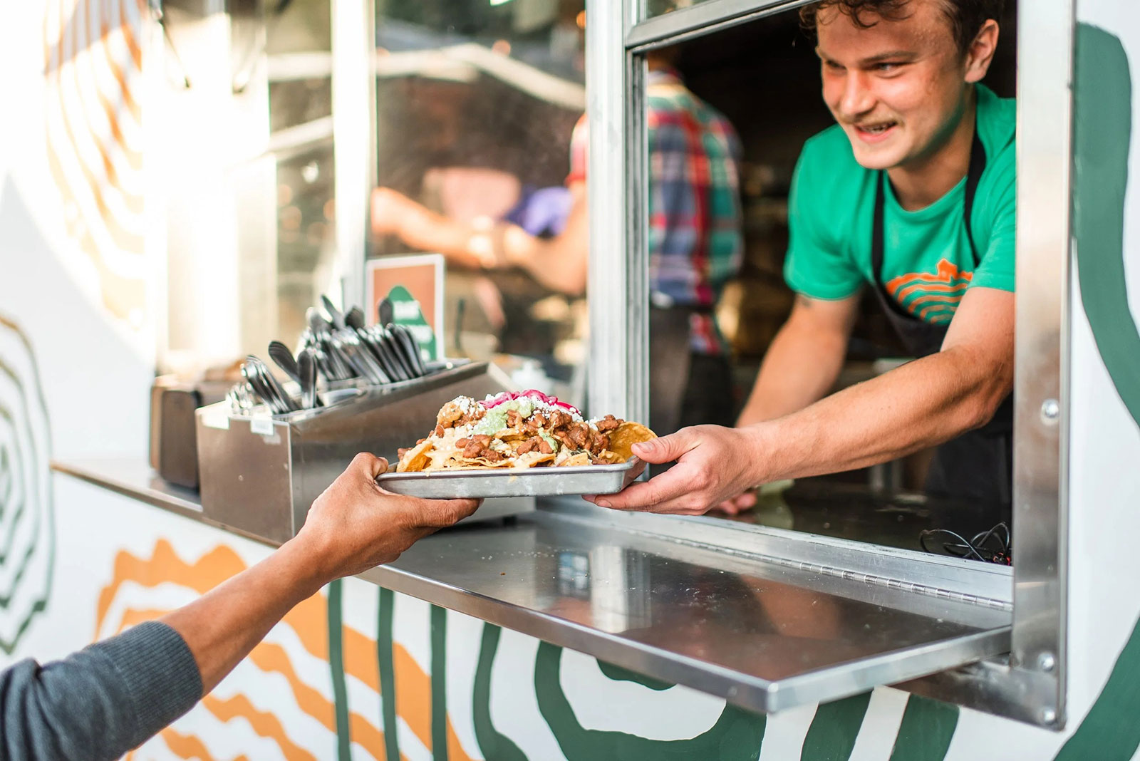 Man serving a plate of food out of a window