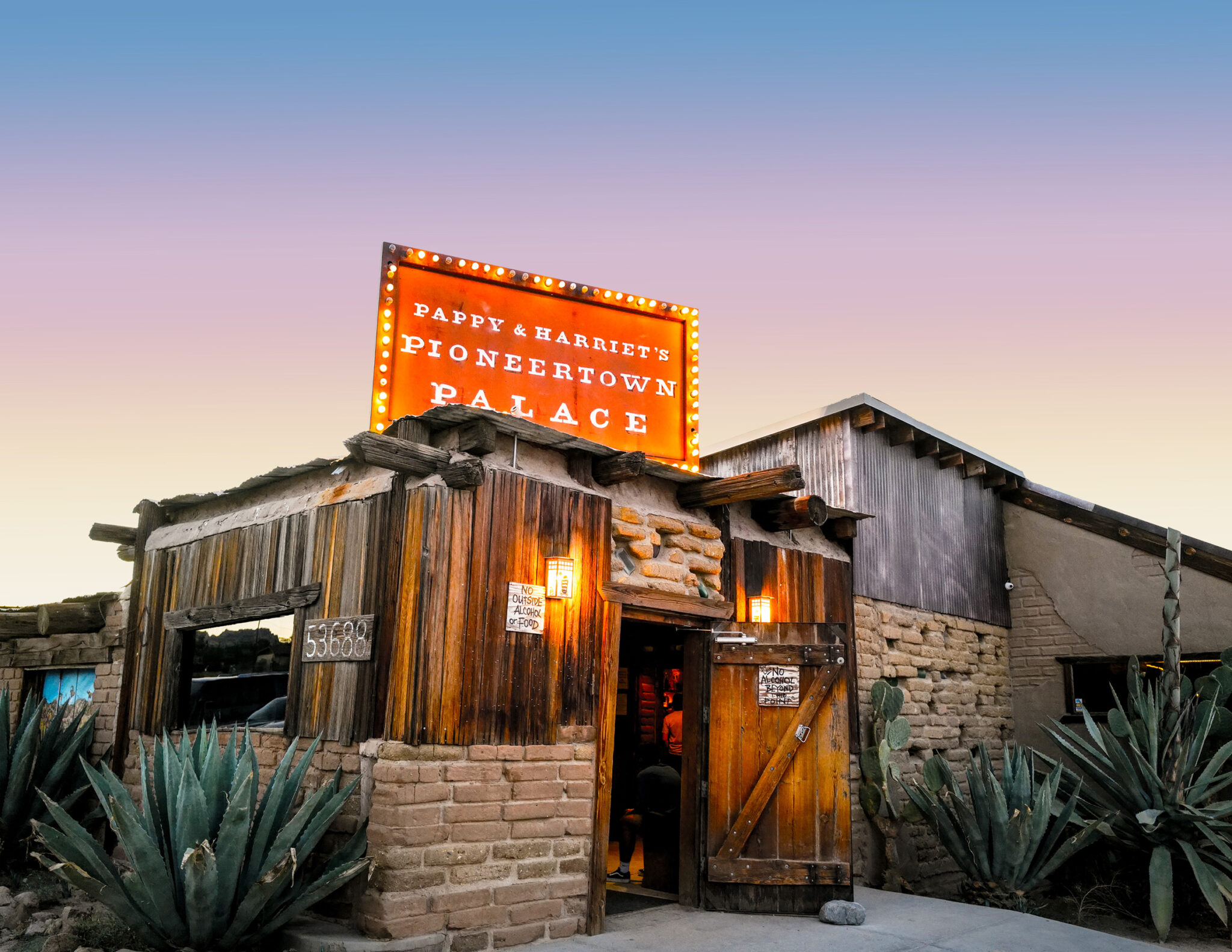 Pappy & Harriets BBQ restaurant exterior with agave plants in the foreground