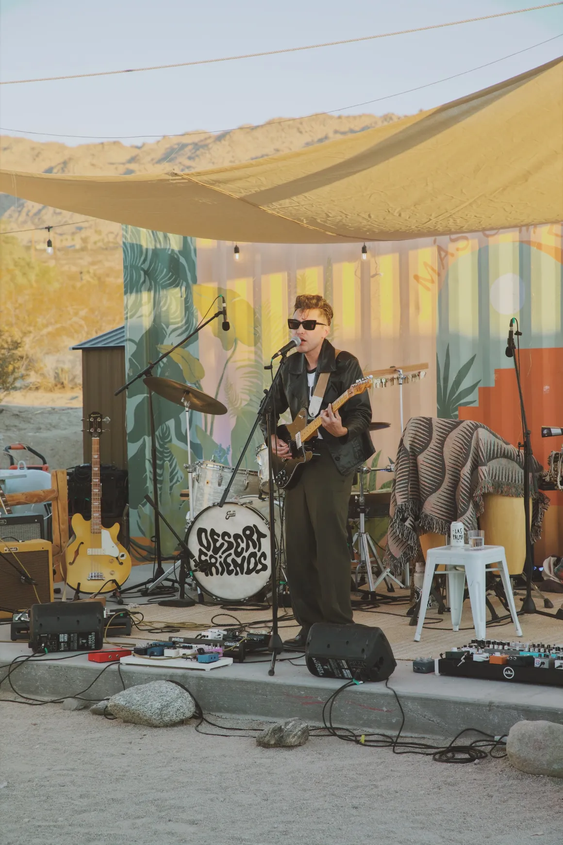 Man with sunglasses playing the guitar in the desert
