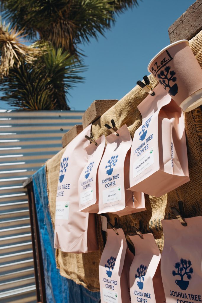 multiple bags of Joshua Tree coffee in pink sacks with blue writing and logo