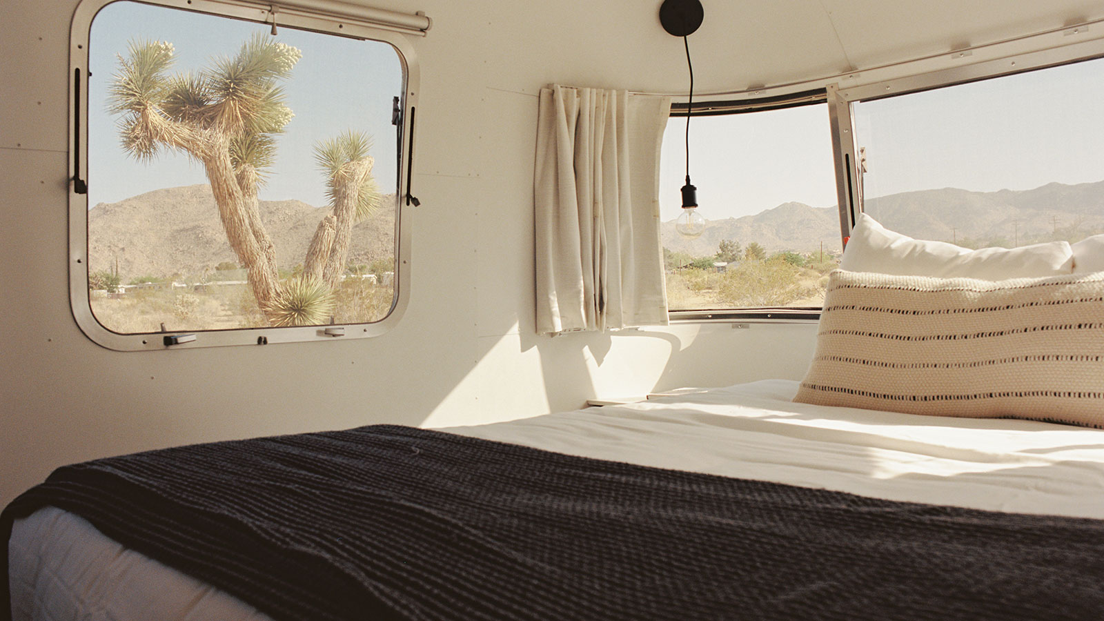 Bed with view of the desert in an Airstream