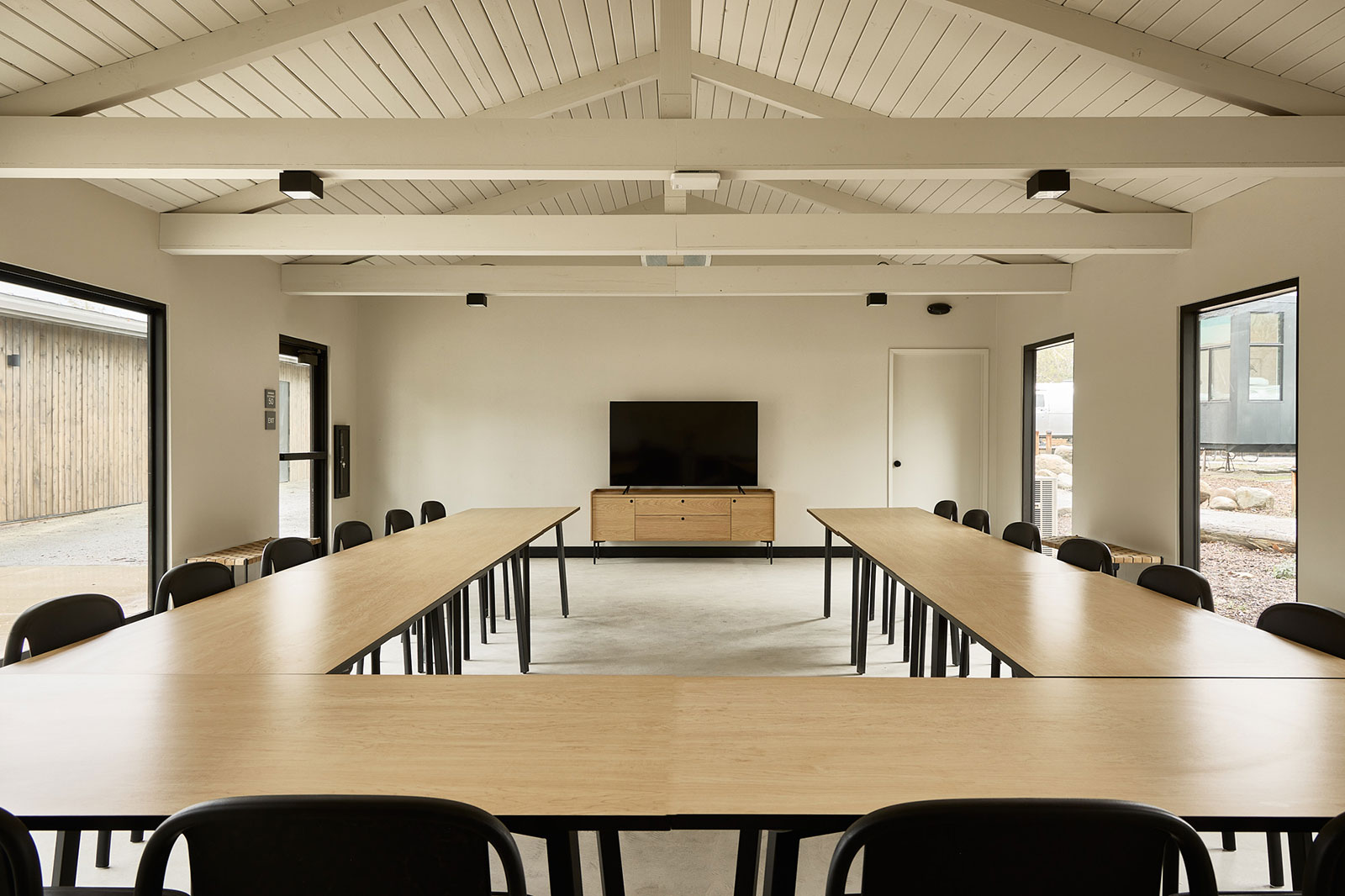 Cedar Room group meeting space at AutoCamp Sequoia with conference tables and chairs in a 