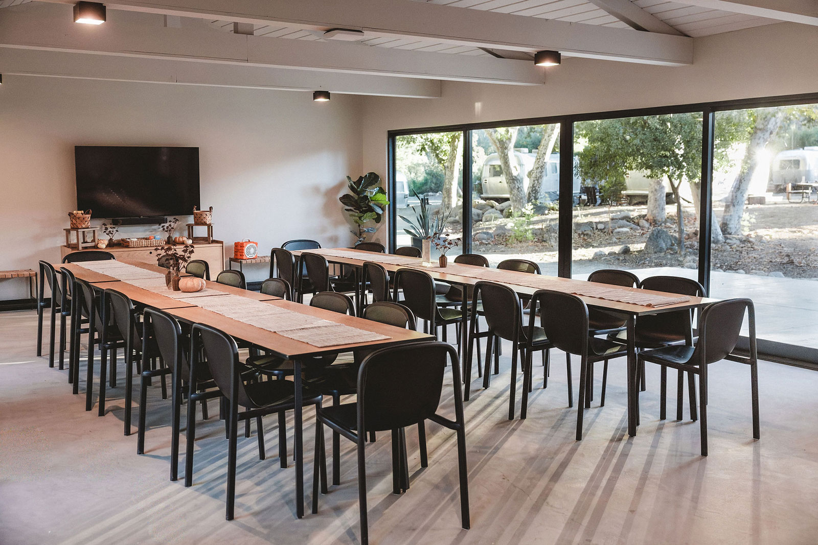 Cedar Room group meeting space at AutoCamp Sequoia with two conference tables and chairs.