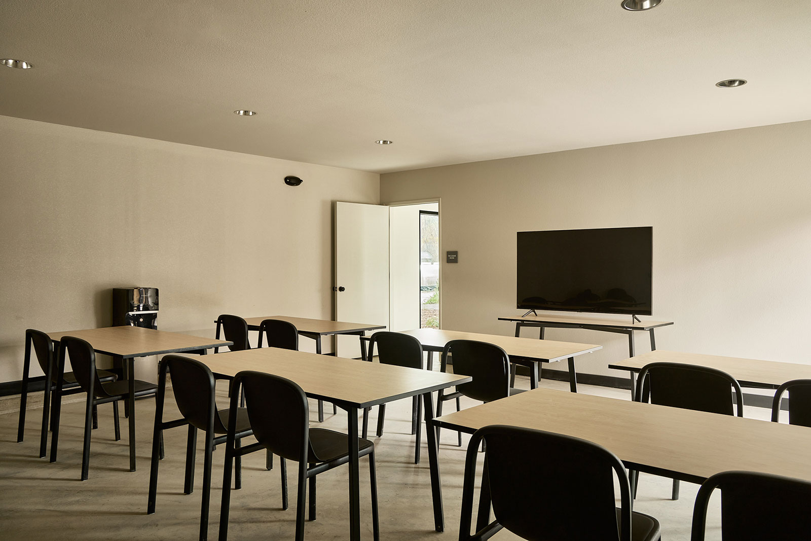 The Pine Room group meeting space at AutoCamp Sequoia with conference tables and chairs.