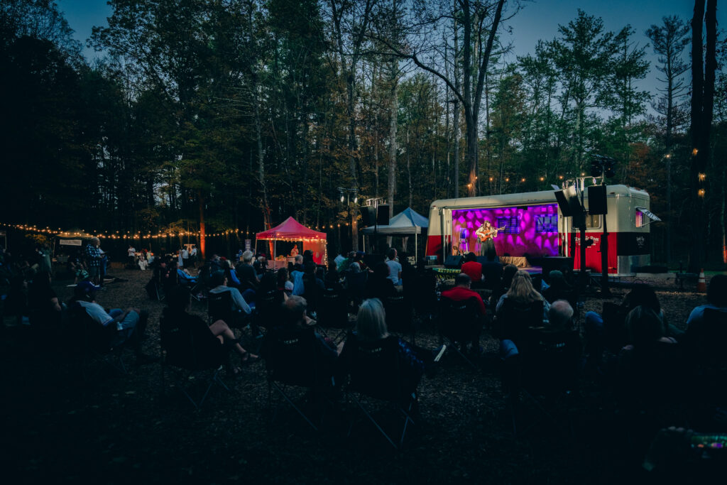 Musician plays music under the lights at AutoCamp Catskills