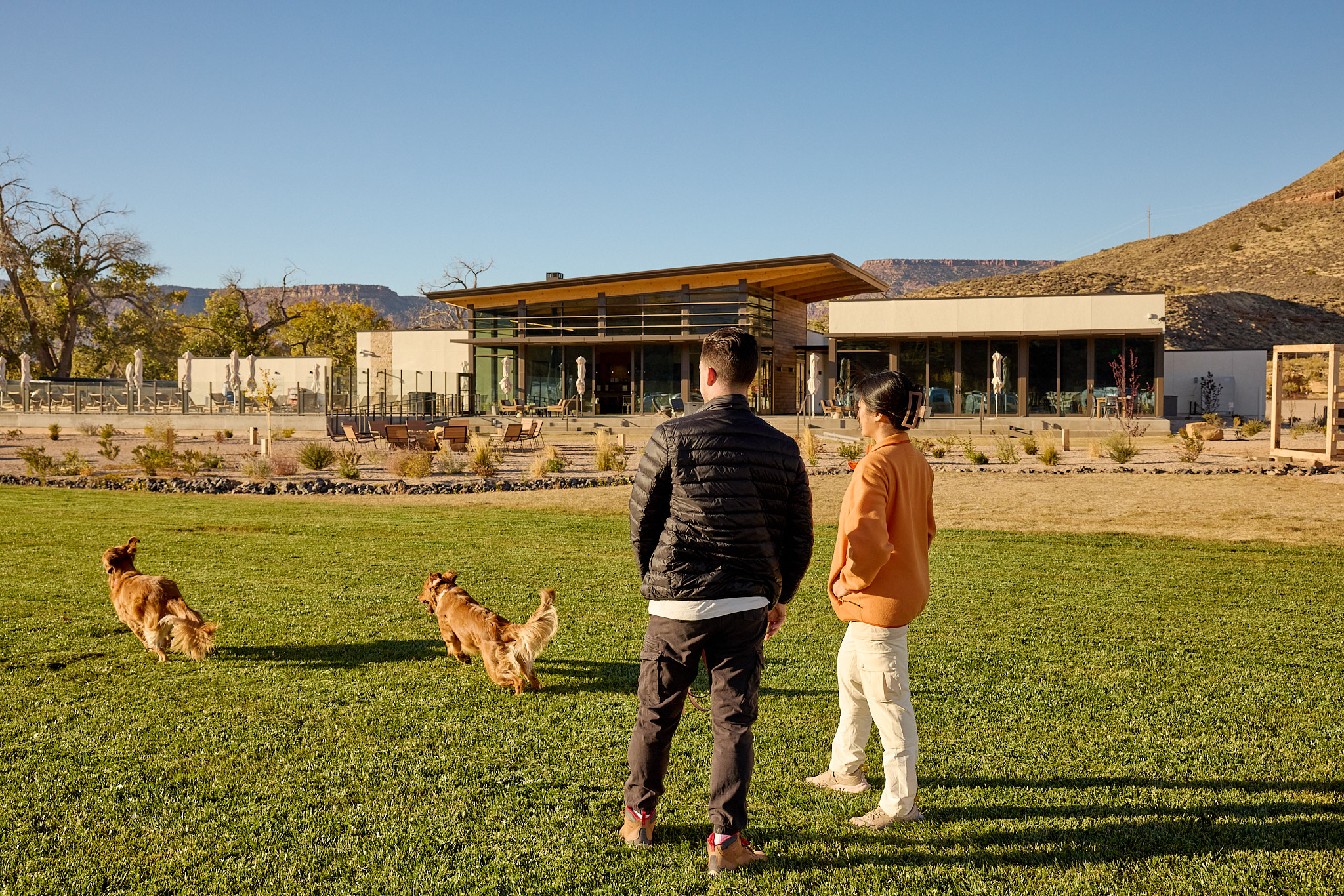 dog and couple on clubhouse lawn at AutoCamp Zion
